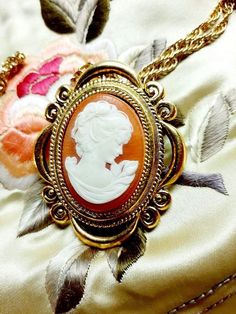 A large pretty 1970s vintage Victorian look cameo solid perfume locket by Max Factor that was never used. This large lovely cameo locket necklace is filled with solid perfume and has a delicate carved plastic cameo on the front.A bright gold tone Victorian style setting makes it a romantic piece to wear.The original gold tone link necklace chain is included.The locket is 2" x 1 1/2"The chain is 13 1/2" long. The solid cream perfume inside hasn't been touched and it still smells lovely. It is ver 70s Victorian, Cameo Locket, Cream Perfume, Perfume Locket, Book Locket, Solid Perfume, Long Chain Necklace, Max Factor, Cat Necklace