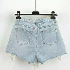 High-waisted, light-wash denim short shorts featuring frayed hems and glamorous, dangling rhinestone fringe. These shorts add a touch of sparkle to your summer wardrobe, perfect for festival fashion or nights out when you want to stand out. The rhinestones catch the light with every move, creating an eye-catching effect that turns heads. Waist measurements in inches. Ladies Denim Shorts, Ripped Jeans Style, Casual Denim Shorts, Womens Ripped Jeans, Ladies Denim, Summer Shorts Denim, Y2k Casual, Ripped Jean Shorts, Casual Bottoms