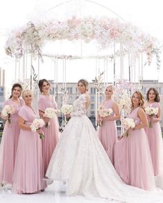 a group of women standing next to each other in front of a white gazebo