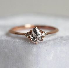 a white diamond ring sitting on top of a white cloth