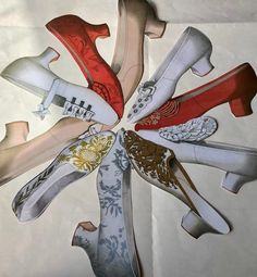 several pairs of shoes are arranged in the shape of a flower on white paper with gold and red accents