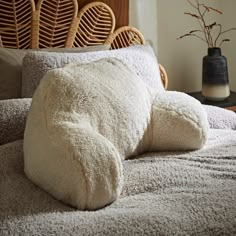 a pillow that is laying on top of a bed with pillows in the shape of an animal