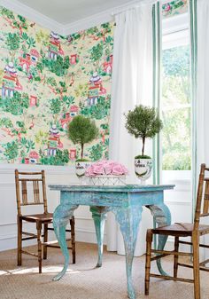 a table and chairs in a room with floral wallpaper