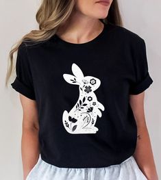 Floral Bunny Shirt - Floral Rabbit Shirt - Easter T-shirt - Spring T-shirt - Bunny Shirt - Nature Lover - Animal Lover - Gift for Her Our Unisex T-shirts are High Quality, SUPER soft and SUPER comfy. They made of 100% Cotton. Heather tees are a soft cotton-poly blend. We use BELLA+CANVAS for our T-shirts! FABRICATION * Solid Colors: 100% Ringspun Cotton * Heather Colors: 52% cotton, 48% polyester * Runs true to size SIZING This style is a unisex t-shirt. If you are unsure about the size you shou Spring Black T-shirt With Cartoon Print, Black Cartoon Print T-shirt For Spring, Black T-shirt With Cartoon Print For Spring, Cute Black T-shirt For Spring, Casual Cotton T-shirt With Bunny Print, Cute Black Printed Tops, Cute Black Shirt For Spring, Casual Bunny Print Crew Neck Top, Cotton Bunny Print T-shirt For Spring