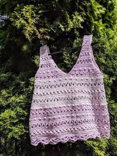 a crocheted tank top hanging from a tree with the text, secret summer tank