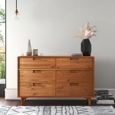 a large wooden dresser sitting on top of a hard wood floor next to a window