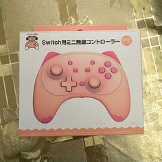 a pink game controller sitting on top of a table