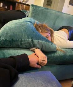 a woman laying on top of a blue couch