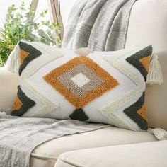 a white couch with a decorative pillow on it