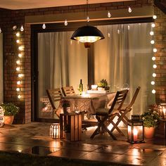 a table and chairs on a patio lit up with lights