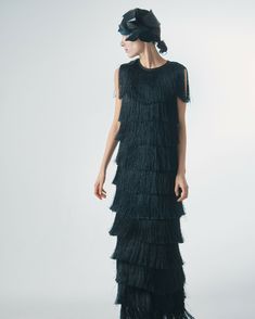 An exquisite and elegant evening dress, crafted from wide rows of fringe, is designed to inspire a truly memorable look. The fringe creates a sophisticated effect of movement and play of light. Thanks to its unique design and attention to detail, it perfectly accentuates your femininity and sophistication. This sleeveless garment, yet covering the shoulders, features a round neckline that adds a touch of charm to the overall look. With a lining for comfort and confidence in movement, it is the p Elegant Floor-length Maxi Dress With Tassels, Glamorous Fringe Evening Dress, Glamorous Evening Dress With Fringe, Elegant Fitted Maxi Dress With Tassels, Elegant Fringe Flapper Dress, Elegant Fringe Cocktail Evening Dress, Elegant Floor-length Flapper Evening Dress, Elegant Floor-length Flapper Dress, Elegant Floor-length Tassel Dresses