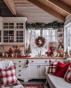 the kitchen is decorated for christmas with red and white plaid pillows on the couches