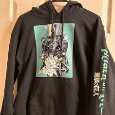 a black hoodie with an image of anime characters on the front and back panels