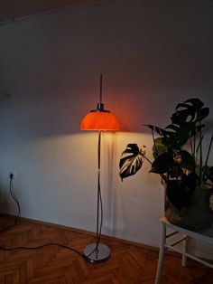 a lamp that is sitting on top of a table next to a potted plant