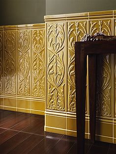 a wooden table sitting on top of a hard wood floor next to a yellow wall