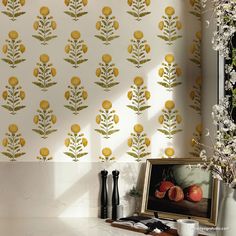 the wall paper has yellow flowers and leaves on it, along with black vases