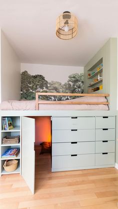 a bedroom with a bed, desk and drawers in it's corner next to a book shelf