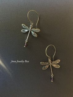 Beautiful silver dragonfly earrings with amethyst beads. Very detailed silver dragonflies are on handmade stainless steel ear hooks. Total earring length is just under 2 inches. *Silver plated brass dragonflies *Stainless steel ear hooks *Faceted amethyst beads *Handmade with love <3 Like Jmesjewelrybox on Facebook for updates on new jewelry, upcoming sales and giveaways! Plus Facebook fans save 5% :D Find the coupon code on Jmesjewelrybox's cover photo https://www.facebook.com/Jmesjewelrybox Dainty Sterling Silver Dragonfly Jewelry, Silver Amethyst Wire Wrapped Earrings, Dainty Silver Dragonfly Jewelry, Elegant Dragonfly Jewelry For Jewelry Making, Nickel-free Silver Amethyst Jewelry, Silver Dragonfly Earrings Perfect For Gifts, Silver Dragonfly Earrings For Gift, Nickel-free Dragonfly Sterling Silver Earrings, Nickel-free Sterling Silver Dragonfly Earrings