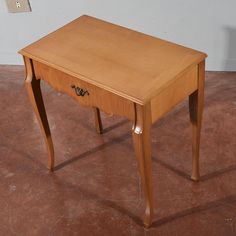 a small wooden table sitting on top of a brown floor