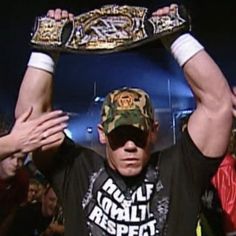 a man holding up a wrestling belt in front of his head