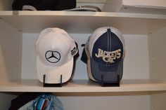 two hats are sitting on top of the shelves