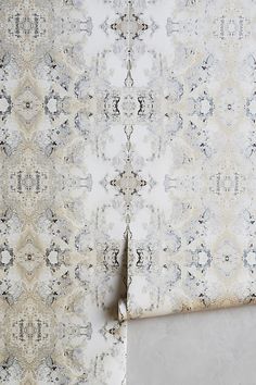 an area rug with white and grey designs on it, next to a wallpaper border