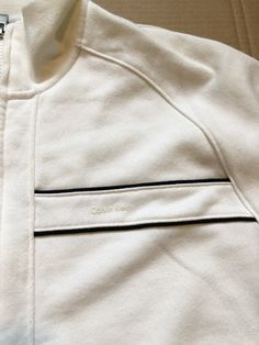 Vintage Calvin Klein Full Zip White Jacket Sweater size Medium. This is a Calvin Klein classic with an awesome look and design. Simple look as a jacket type sweater that is perfect for the spring and fall season. Great condition. Classic Sweatshirt For Spring Streetwear, Classic Spring Sweatshirt For Streetwear, Classic Spring Streetwear Sweatshirt, White Outerwear With Ribbed Collar For Spring, White Outerwear With Ribbed Collar For Fall, White Ribbed Collar Outerwear For Spring, Fall White Outerwear With Ribbed Collar, White Cotton Outerwear With Ribbed Collar, White Classic Sweatshirt For Spring