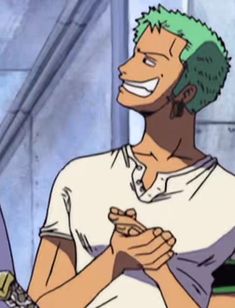 a man with green hair is smiling and holding his hands together