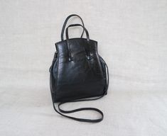 "Stylish black leather handbag/shoulder.  Inside one slip pocket. Magnetic closure.  Bag strap has signs of use as can see in picture. Measurements: Width: top 6/15cm, bottom 8''/20cm Height: 8\"/20cm Depth: 2,5\"/6cm at the bottom Shoulder strap: 37\"/94cm Handle drop: 15\"/38cm Please contact me for any questions." Black Soft Leather Handheld Satchel, Black Crossbody Satchel With Handle Drop, Black Handheld Bucket Bag With Handle Drop, Black Satchel With Handle Drop, Black Satchel Shoulder Bag With Handle Drop, Black Leather Handbag, Top Handle Bags, Black Leather Purse, Handbag Black