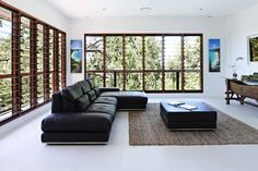 a modern living room with large windows and leather couch in front of the window seat