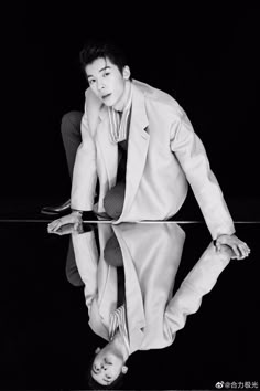 a man in a suit and tie leaning on a table