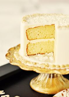 a white cake sitting on top of a gold plate