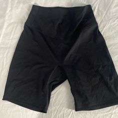 black shorts laying on top of a white sheet