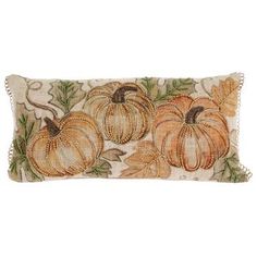 a decorative pillow with three pumpkins on it