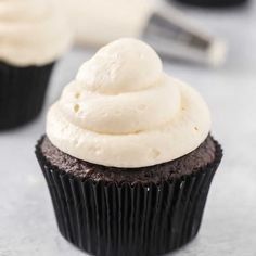 two cupcakes with white frosting on top