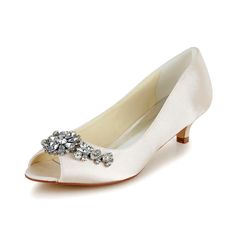 a women's white shoe with a flower on the toe and an embellished buckle