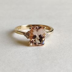 ITEM DESCRIPTION: >> The Ring is made from Solid 14K Yellow Gold. Gemstone used is absolutely natural and ethically sourced. >> Natural Morganite in Emerald Cut and Rectangle cushion shape is studded on it with utmost precision. >> This is a minimalist design which makes it a hassle free and everyday jewelry. Gem: Morganite Gem size: 9×7mm Gem Weight: 1.915 carats and cushion shape Gem: Diamond Gem size: 1.50mm and Round Gem Weight: 0.089 carats Gold purity: 14K (58.33% approx.) Gold weight: 2.4 Classic Morganite Diamond Ring In Yellow Gold, Heirloom Gold Ring With Morganite, Classic Gold Morganite Jewelry, Classic Morganite Gold Jewelry, Heirloom Gold Morganite Ring, Heirloom Morganite Round Cut Rings, Heirloom Morganite Gold Ring, Heirloom Morganite Rings, Yellow Gold Morganite Gemstone Rings