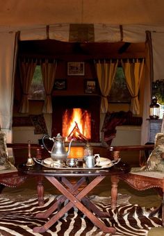 a living room filled with furniture and a fire place in the fireplace surrounded by curtains