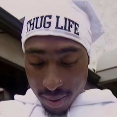 a man wearing a white hat with the word hug life on it's side