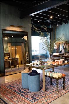 a room filled with lots of furniture and rugs on top of a wooden floor