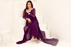 Expertly crafted in a rich plum purple hue, this long Shalwar Kameez features a flattering a-line silhouette. Adorned with intricate mukesh shirt work and a hand-embroidered neckline, this suit exudes elegance and sophistication. Perfect for formal occasions, this piece is sure to make a statement. 3-Piece Suit Elegant Semi-stitched Purple Sets, Elegant Purple Kurta With Mirror Work, Elegant Purple Sharara For Party, Elegant Purple Sets With Mirror Work, Purple Long Sleeve Sets With Mirror Work, Elegant Purple Kurta With Sheer Dupatta, Purple Georgette Salwar Kameez With Dabka, Elegant Purple Sharara With Chikankari Embroidery, Elegant Purple Anarkali Set With Sheer Dupatta