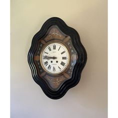 a clock on the wall with roman numerals and numbers in black, brown and white