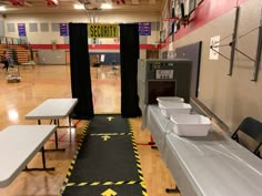 Entrance rugs sere taped down with caution tape/ tables covered with silver table cloths, large box with duct tape “flaps” to slide boxes through (Allowed us to make sure they brought water bottles and added  other supplies as it passed through the “scanner”.). Black curtains over pvc pipe frame for walk-through scanner. Airport Party Decorations, Airport Classroom Transformation, Airport Birthday Party, Airport Theme Preschool, Airport Decorations Travel Themes, Airport Theme Classroom, Airport Classroom Theme, Travel Theme Event