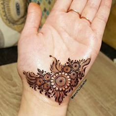 a woman's hand with a henna tattoo on it