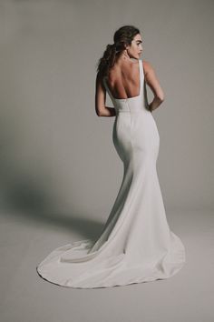 a woman in a white wedding dress with her back to the camera