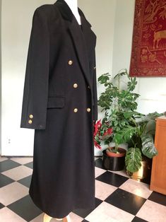 WOOL MAXI COAT  Need a warm winter coat?   Here's a double breasted maxi  coat to keep the chills away.  Black with gold buttons down  front and on cuffs. Velvet collar.  Super clean inside and out.   Estate sale  Mint condition  Made by Levine size medium  Shoulder to bottom 49" Sleeve length 24.5" Arm opening circumference 22" Shoulder back 18" Chest 42" Classic Long Outerwear For Evening, Classic Long Evening Outerwear, Classic Black Long Pea Coat, Classic Long Black Pea Coat, Long Wool Coat For Business, Long Pea Coat For Workwear, Formal Long Single-breasted Pea Coat, Wool Maxi Coat, Opera Coat