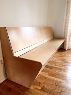 a wooden bench sitting on top of a hard wood floor next to a white door