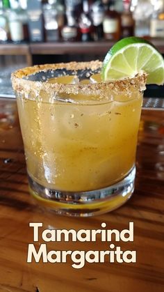 a close up of a drink on a table with the words tamarind margarita