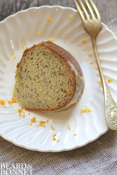 a piece of cake sitting on top of a white plate next to a gold fork