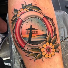 a man's leg with a ship and flowers in the frame on top of it